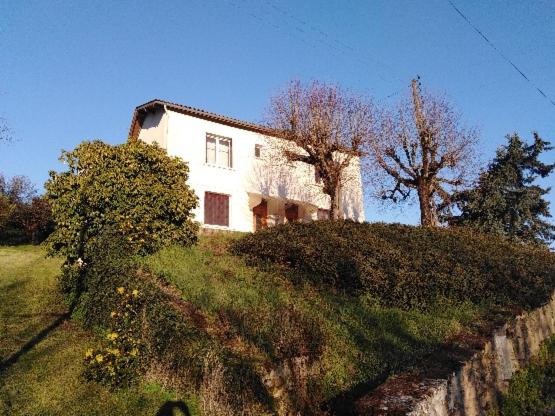 chez Patricia في Cransac: منزل أبيض على قمة تلة
