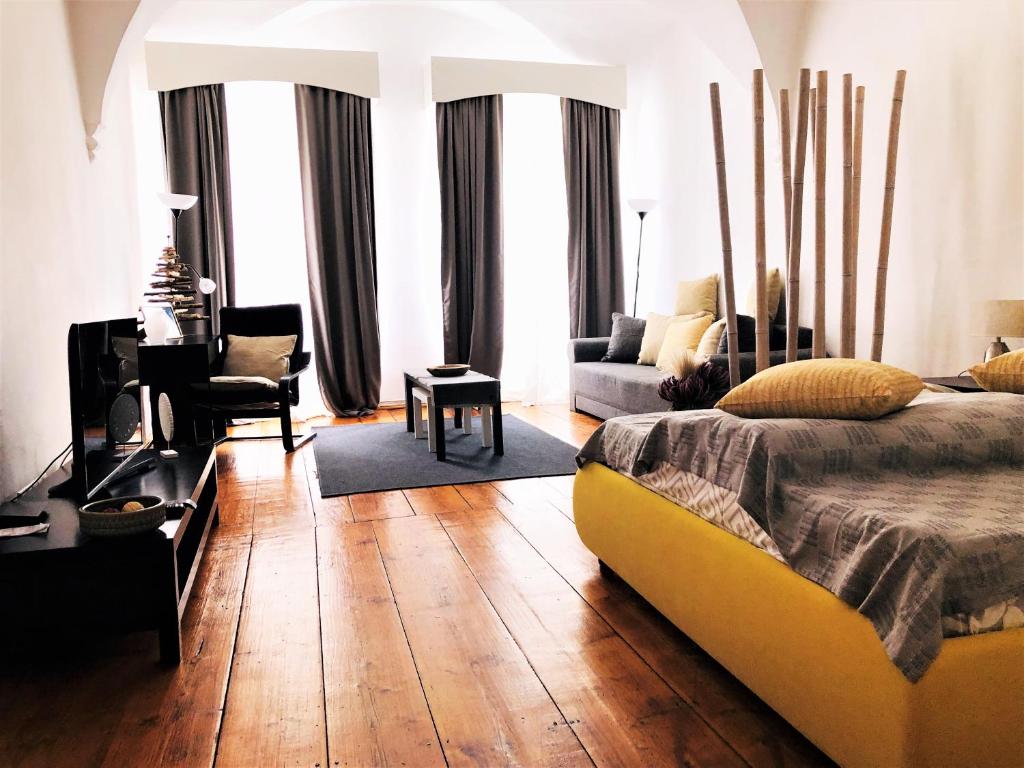 a bedroom with a bed and a living room at Arcade Apartment in Sibiu