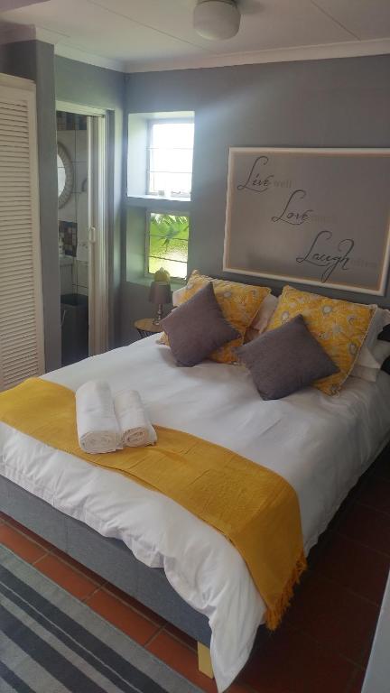 Love Joy Peace Cottage في بريتوريا: سرير كبير عليه منشفتين