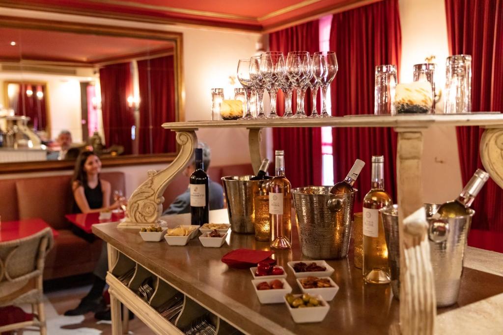 a table with food and bottles of wine in a restaurant at Le Cavendish in Cannes