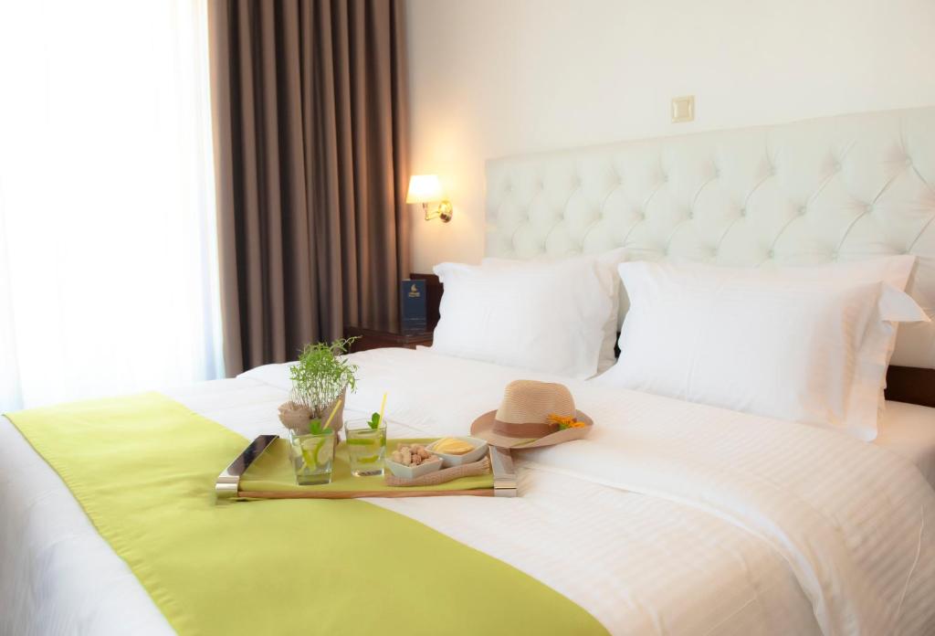 a white bed with a tray of food on it at Armata Boutique Hotel in Spetses