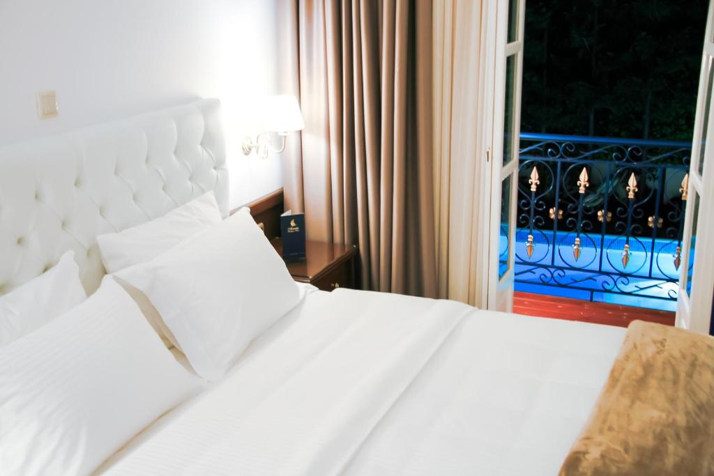 a white bed in a hotel room with a window at Armata Boutique Hotel in Spetses