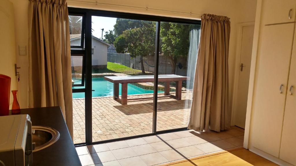 a kitchen with a sliding glass door leading to a pool at Blouberg Beach Retreat in Bloubergstrand