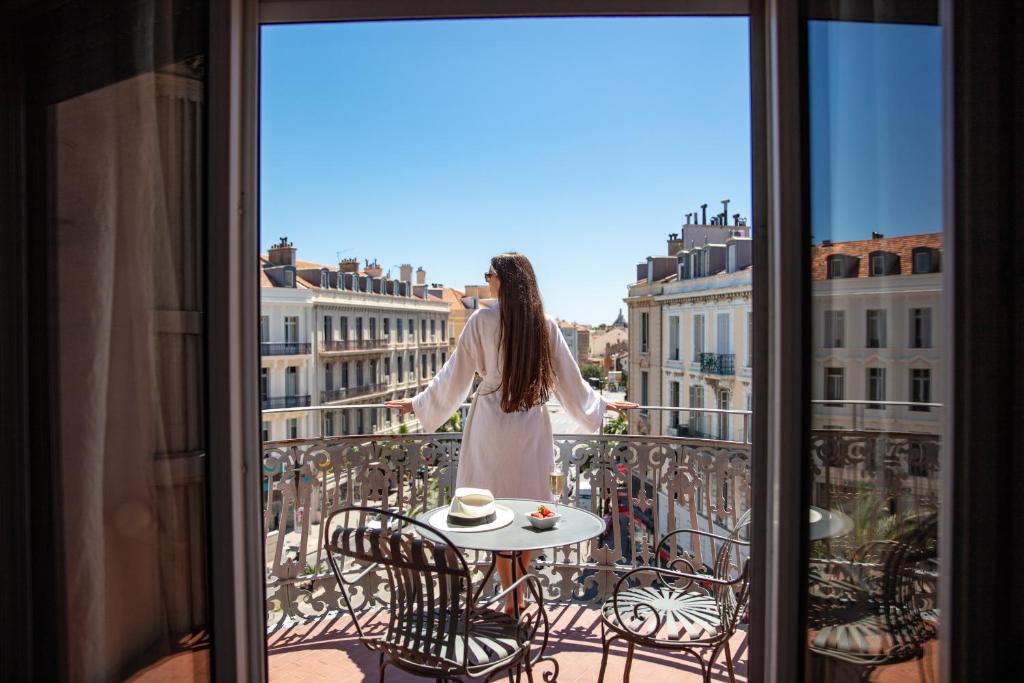 Una donna in piedi su un balcone che guarda la città di Le Cavendish a Cannes