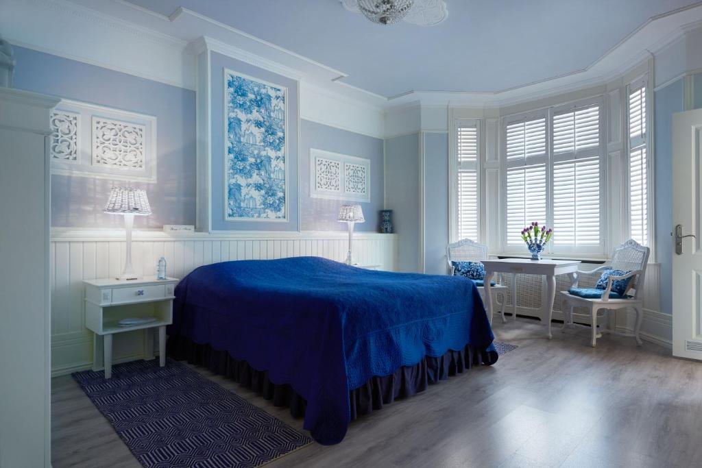 a bedroom with a blue bed and a desk at Vondelpark House B&B in Amsterdam