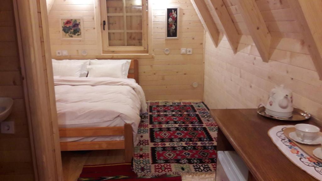 Kleines Zimmer mit einem Bett und einem Tisch in der Unterkunft Karadžić in Žabljak
