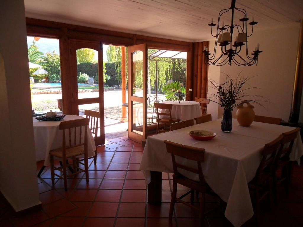 uma sala de jantar com duas mesas com toalha de mesa branca em Hotel Posada Colchagua em Santa Cruz