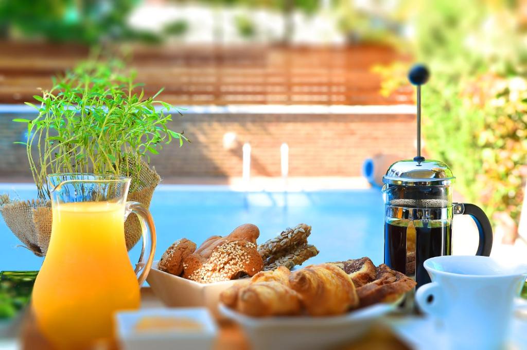 a table with a plate of bread and a glass of orange juice at Armata Boutique Hotel in Spetses