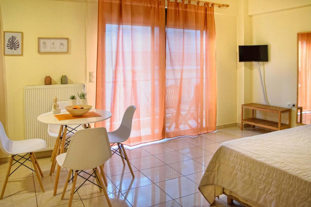a bedroom with a bed and a table and chairs at Sunny City Studio in Kalamata