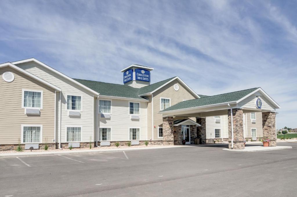 a large white building with a blue tower on top at Cobblestone Inn and Suites - Eaton in Eaton