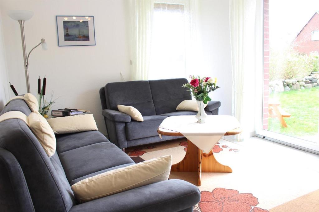 a living room with two couches and a table at Strandgut-Tating in Tating