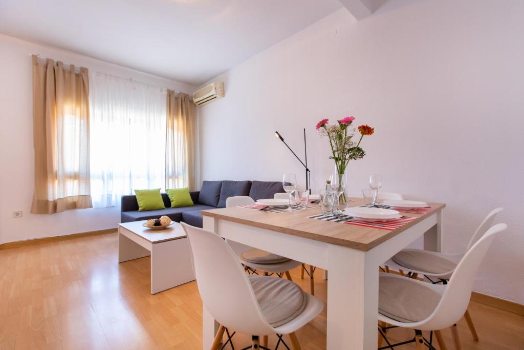 バルセロナにあるスティ バルセロナ ボルネ アパートメントの白いリビングルーム(テーブル、椅子付)