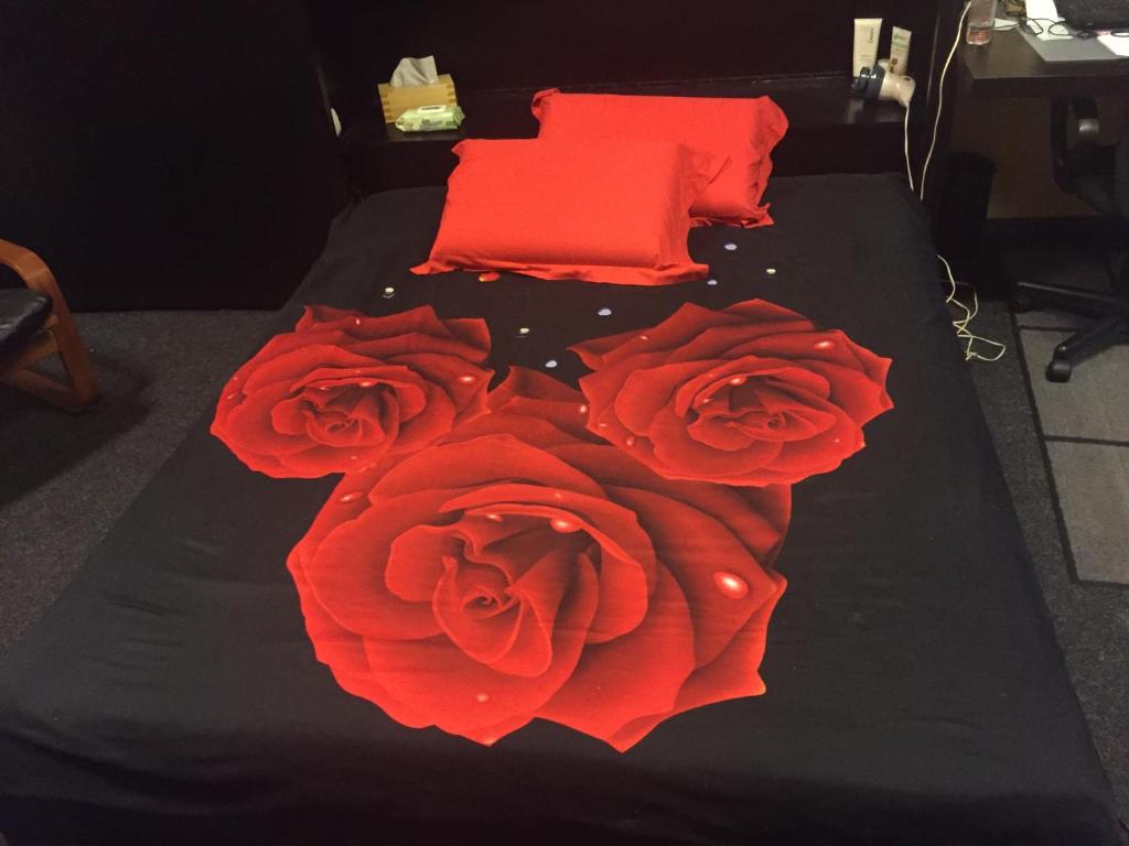 un grupo de rosas rojas en una cama en 4 Stars Magheru Studio, en Bucarest