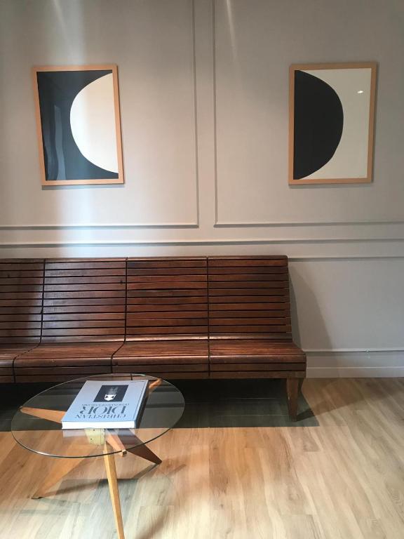 a bench in a room with a table and two pictures at Suites Menaggio in Menaggio