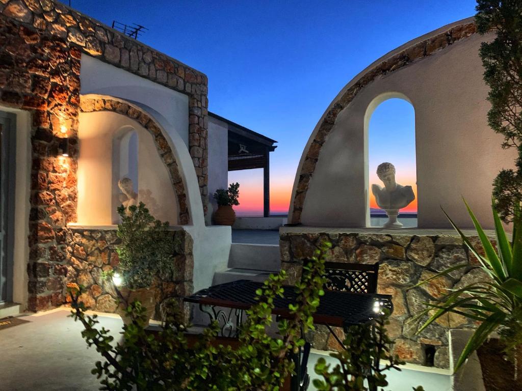 a house with two windows and a stone wall at Grande Murano in Fira