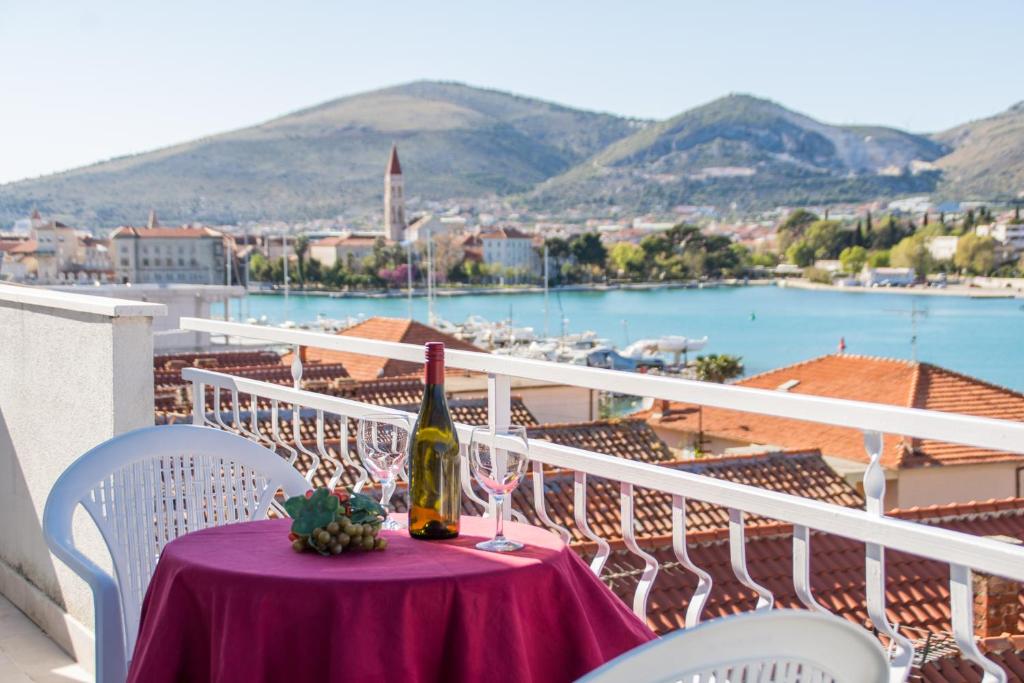 a bottle of wine sitting on a table on a balcony at Villa Jadran in Trogir