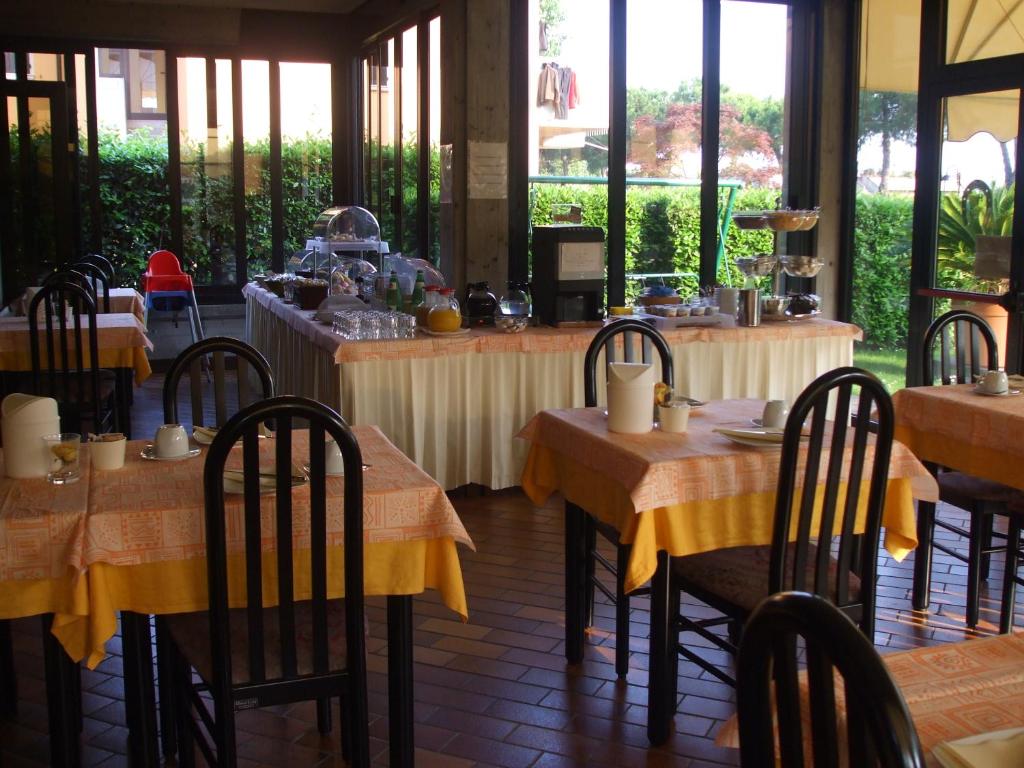 restauracja ze stołami i krzesłami z żółtą tkaniną w obiekcie Hotel Derby w Sirmione