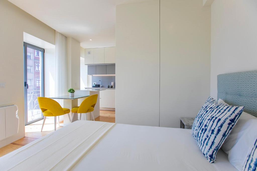 um quarto branco com uma cama e uma mesa em Casa São Lázaro no Porto