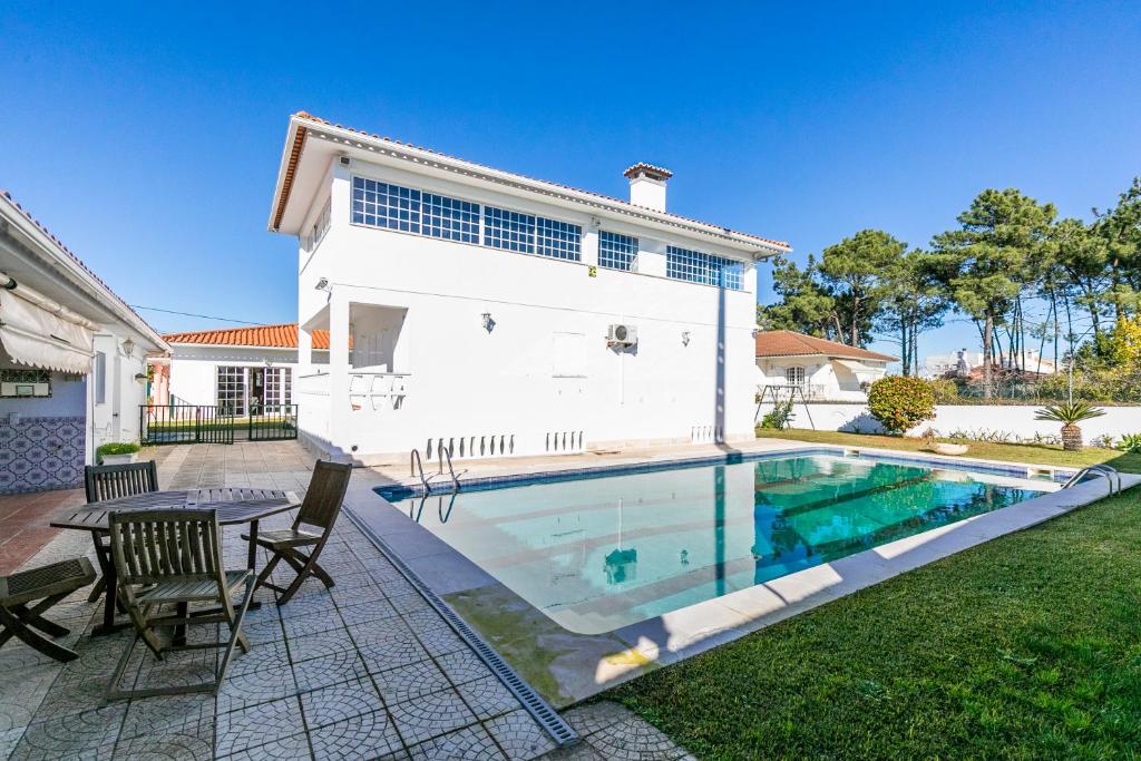 a house with a pool and a table and chairs at AYAMI Villa in Setúbal