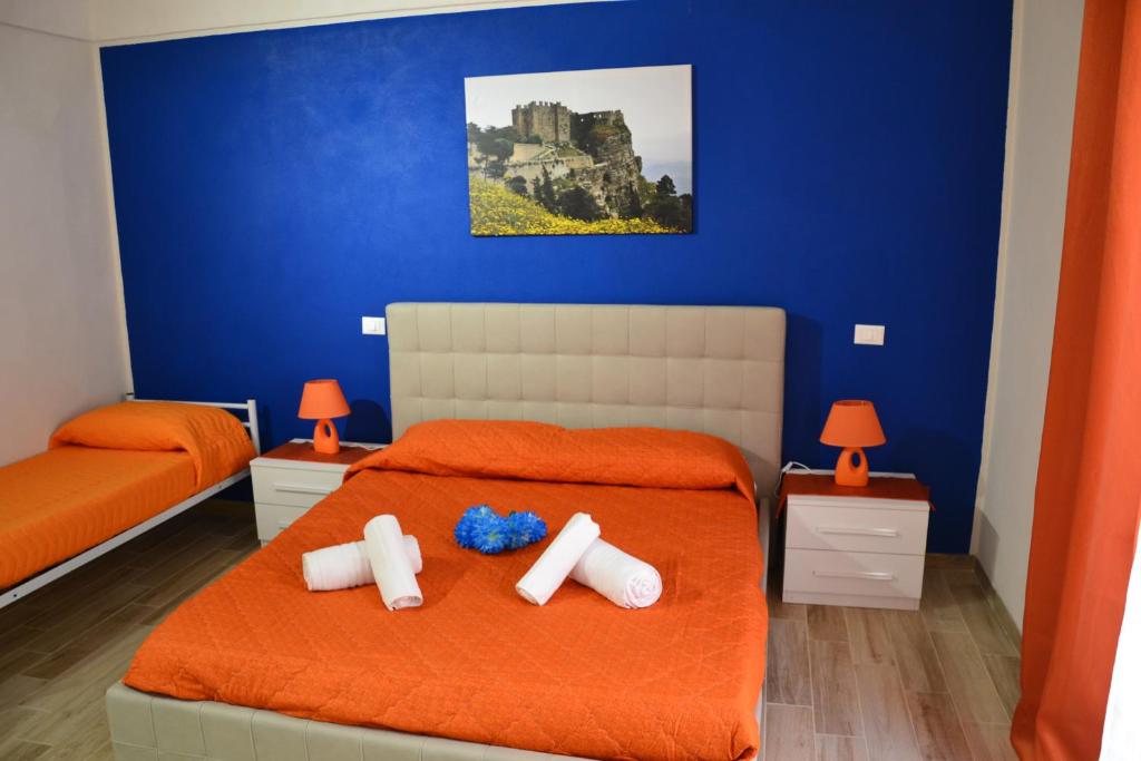 a bedroom with two beds and a blue wall at B&B Stella Maris Trapani Centro in Trapani