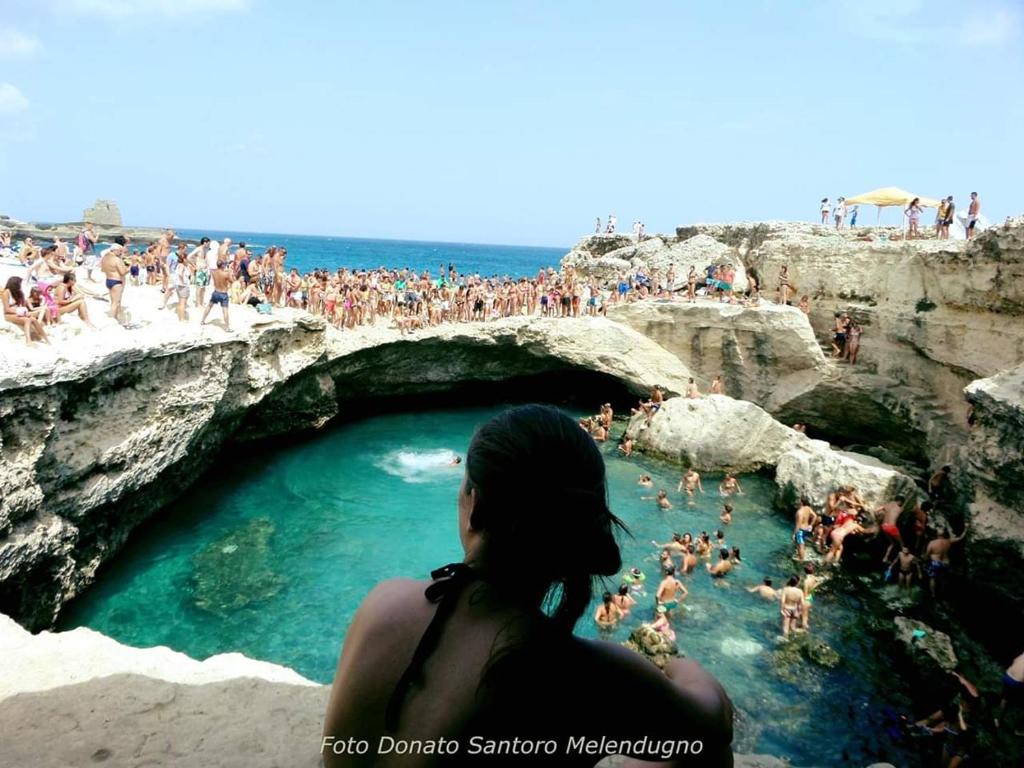 a woman standing in a swimming pool at the beach at Villetta Carati in Torre dell'Orso