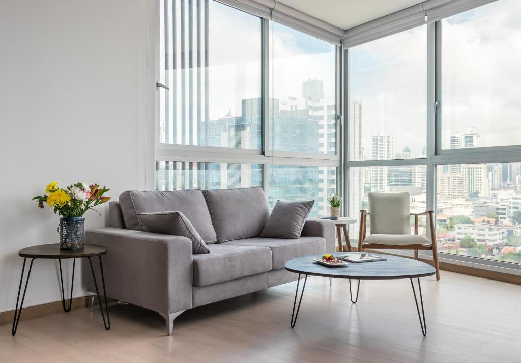 uma sala de estar com um sofá e uma mesa em New Modern City View Apartment - PH Quartier Del Mar na Cidade do Panamá