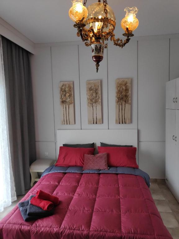a bedroom with a large red bed with a chandelier at Cozy apartments in Komotini
