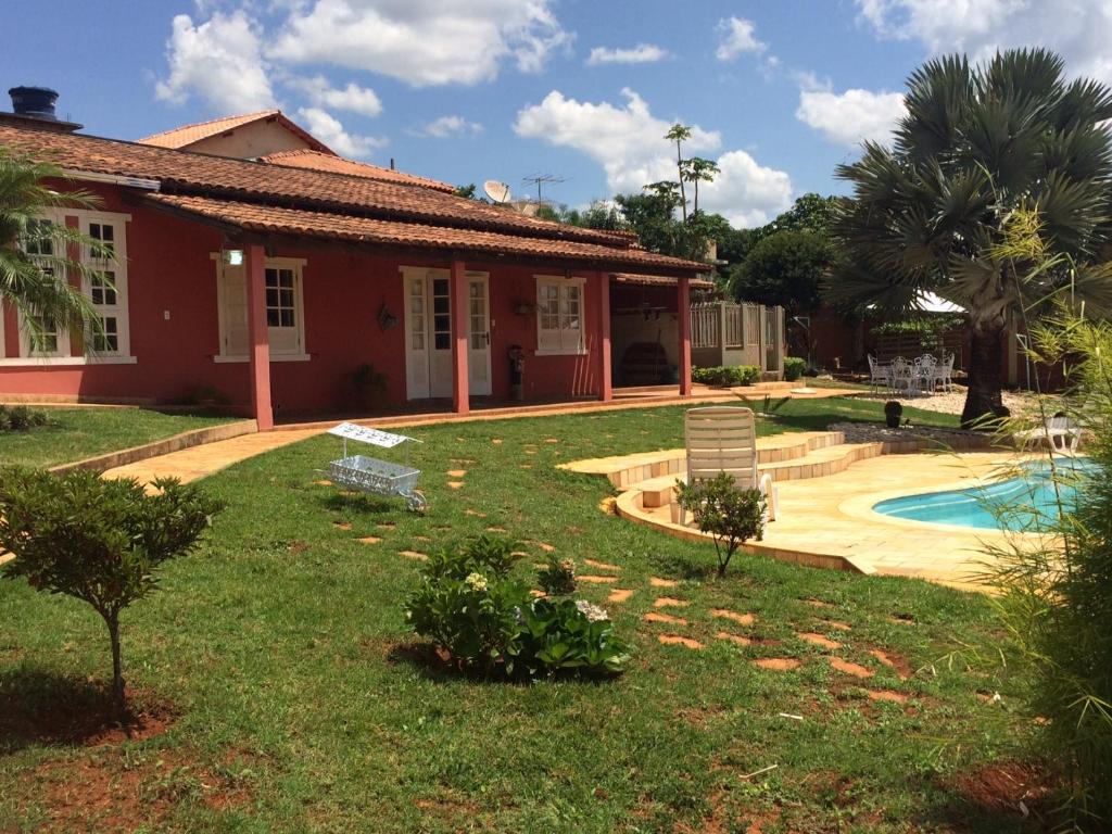 a house with a yard with a swimming pool at Chalé da Serra in São João del Rei