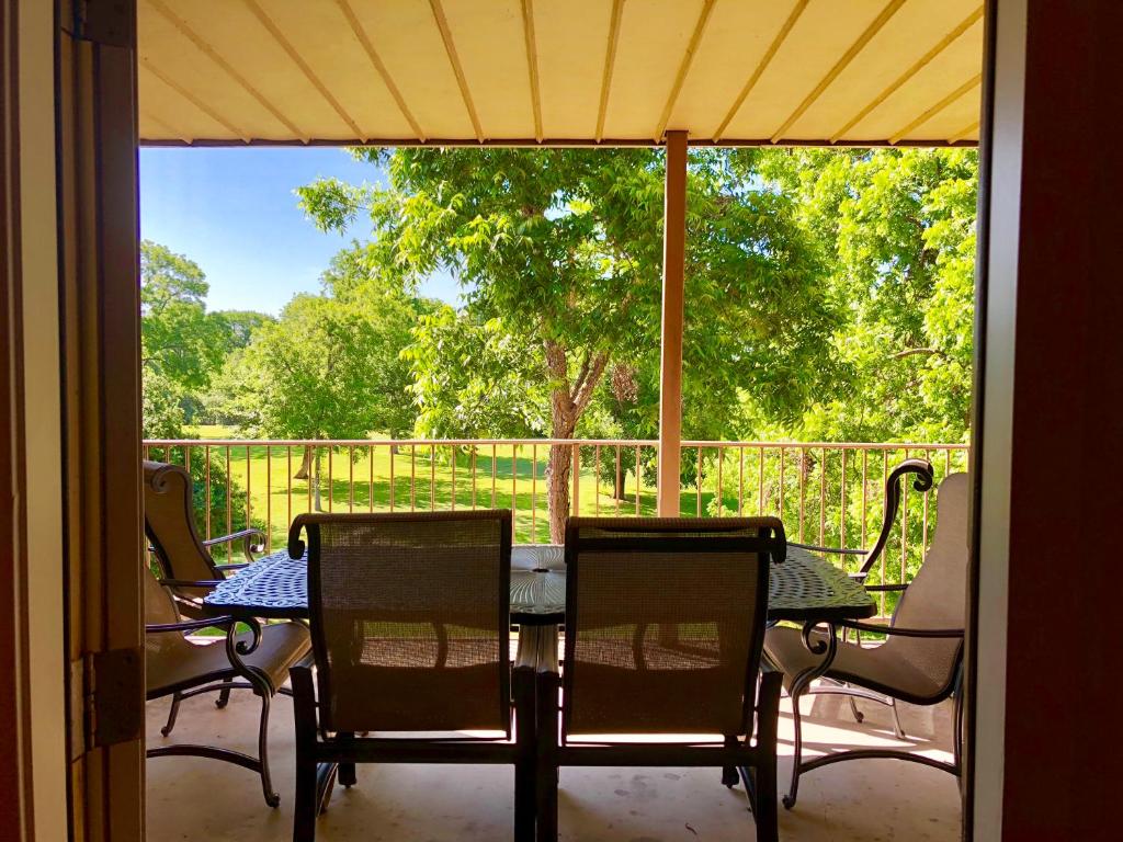 a screened in porch with a table and chairs at Rose' River Retreat in New Braunfels