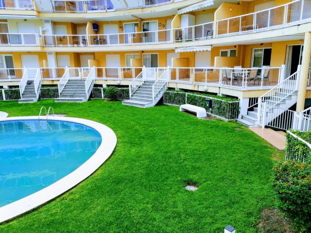 an exterior view of a hotel with a pool and lawn at Parquemar VIII Solo Familias Serviplaya in Playa de Xeraco