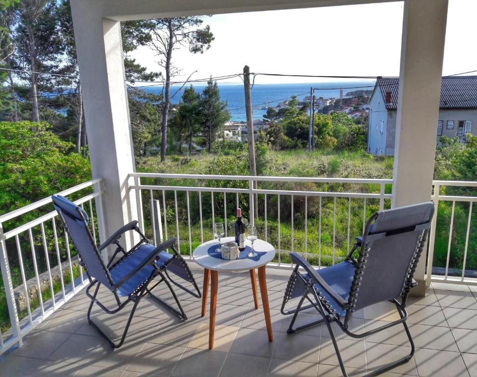 d'une terrasse avec 2 chaises et une table sur un balcon. dans l'établissement Rab - Apartman Matea, à Rab