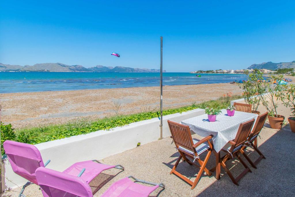 a table and chairs with a view of the beach at Villa LA CALMA Alcudia in Alcudia