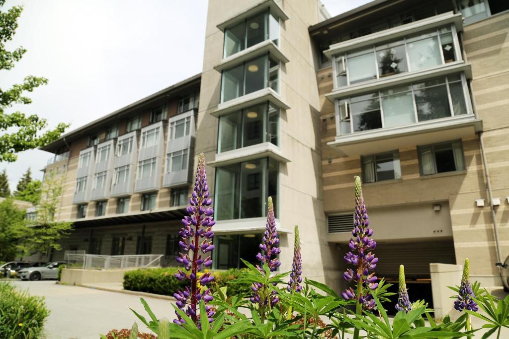 a building with purple flowers in front of it at Carey Centre on UBC campus in Vancouver