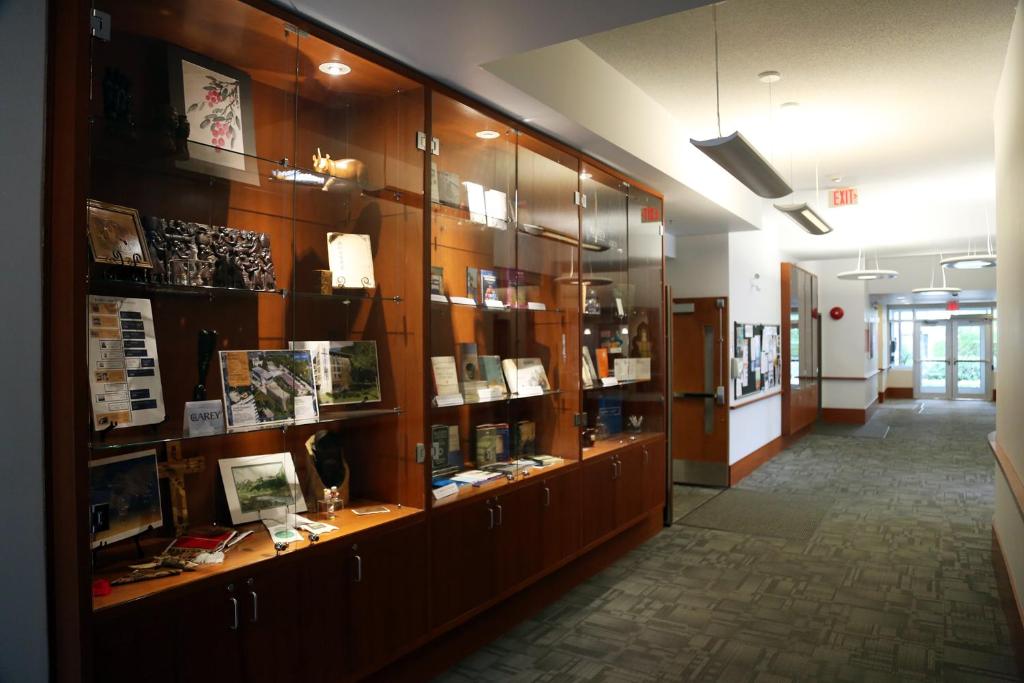 a room with a large wooden display case with books at Carey Centre on UBC campus in Vancouver