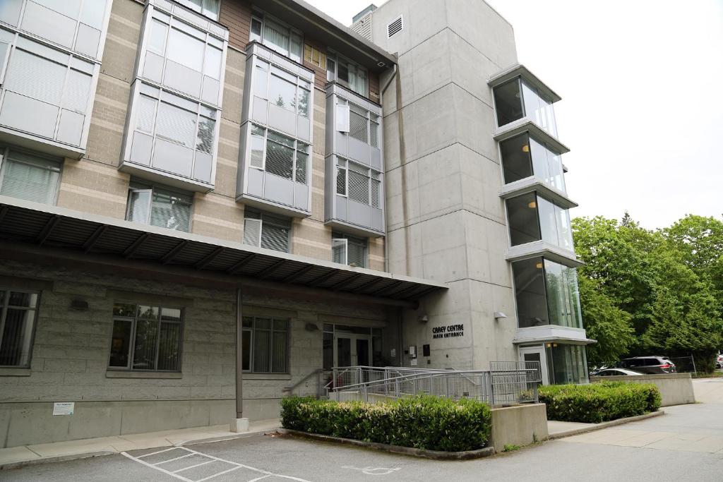 a building with a parking lot in front of it at Carey Centre on UBC campus in Vancouver