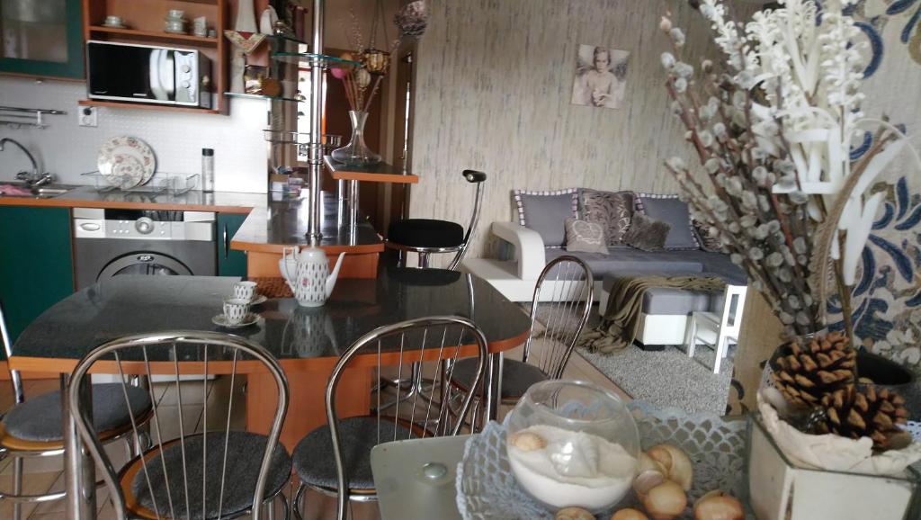 kuchnia i salon ze stołem i krzesłami w obiekcie Apartmán Romance w mieście Komárno