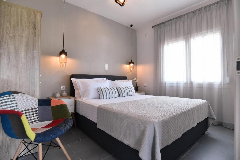 a bedroom with a bed and a chair and a window at Notos apartment in Skala Kallirachis