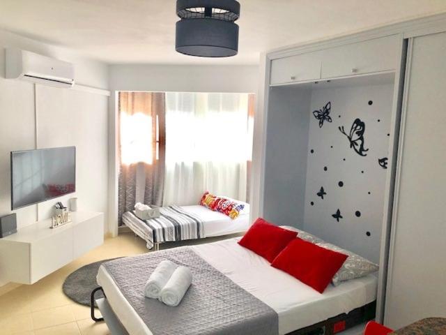 a bedroom with a bed with red pillows and a window at Studio in The Center of Torremolinos in Torremolinos