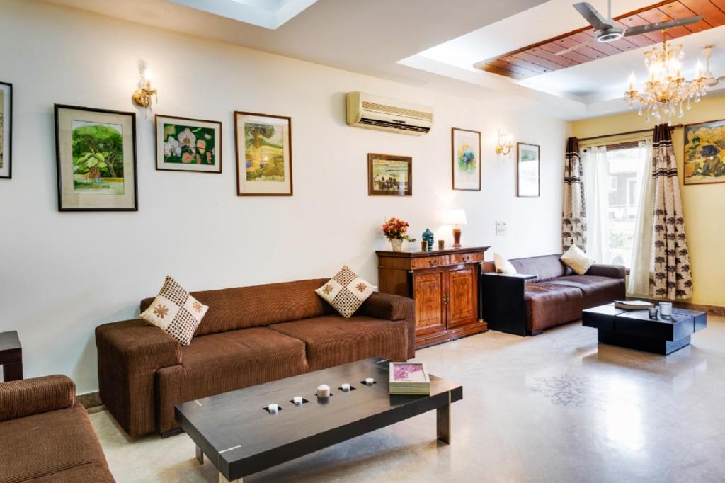 a living room with a couch and a table at Hostie - 4BHK Apartment with lift near Greater Kailash, South Delhi in New Delhi