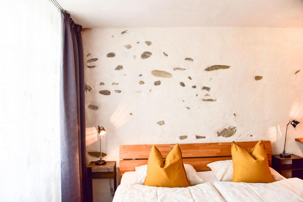 1 dormitorio con 2 camas con almohadas amarillas en The Old Town Flat en Murten