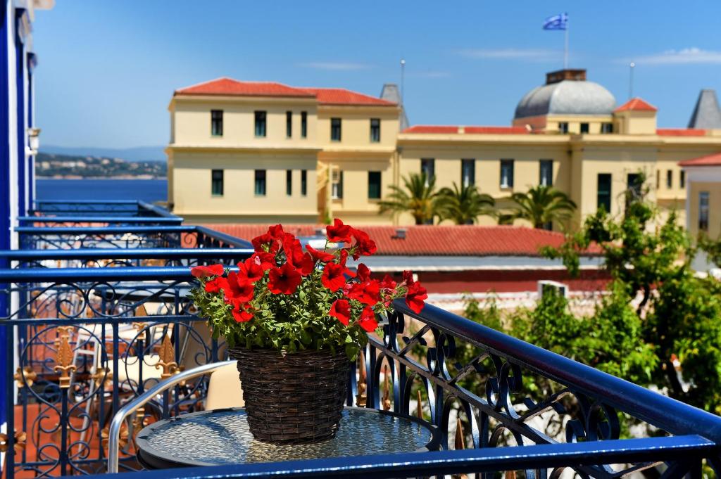 a vase with red flowers sitting on a table on a balcony at Armata Boutique Hotel in Spetses
