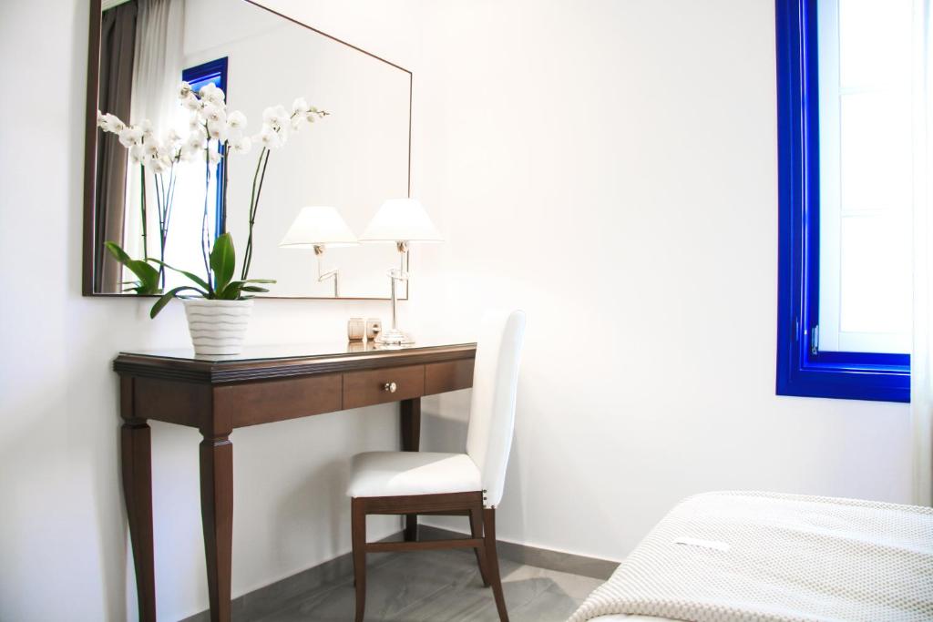 a room with a desk with a chair and a mirror at Armata Boutique Hotel in Spetses