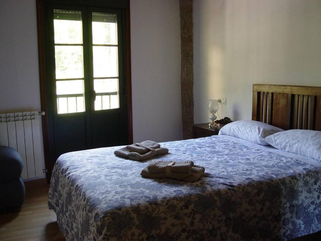 sypialnia z łóżkiem i dwoma ręcznikami na nim w obiekcie Casa en Viñoas (Ribeira Sacra) w mieście Viñoás