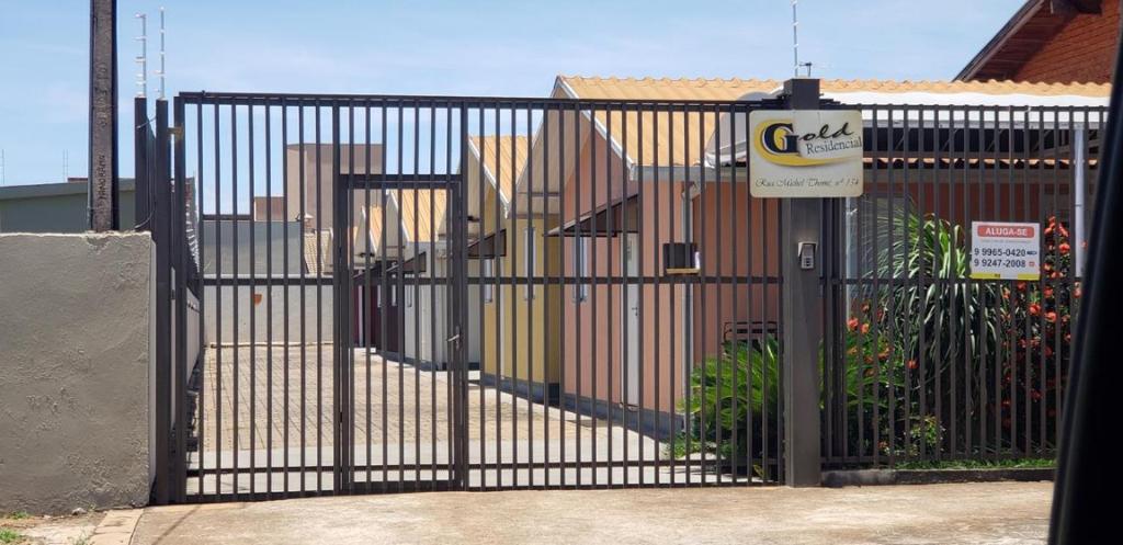 a black gate with a sign in front of it at Casa mobiliada in Três Lagoas