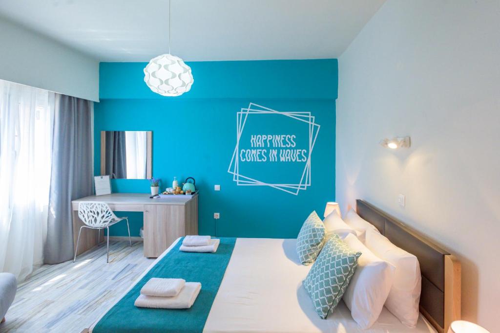 a bedroom with blue walls and a bed with a desk at Magnolia Rooms in Benitses