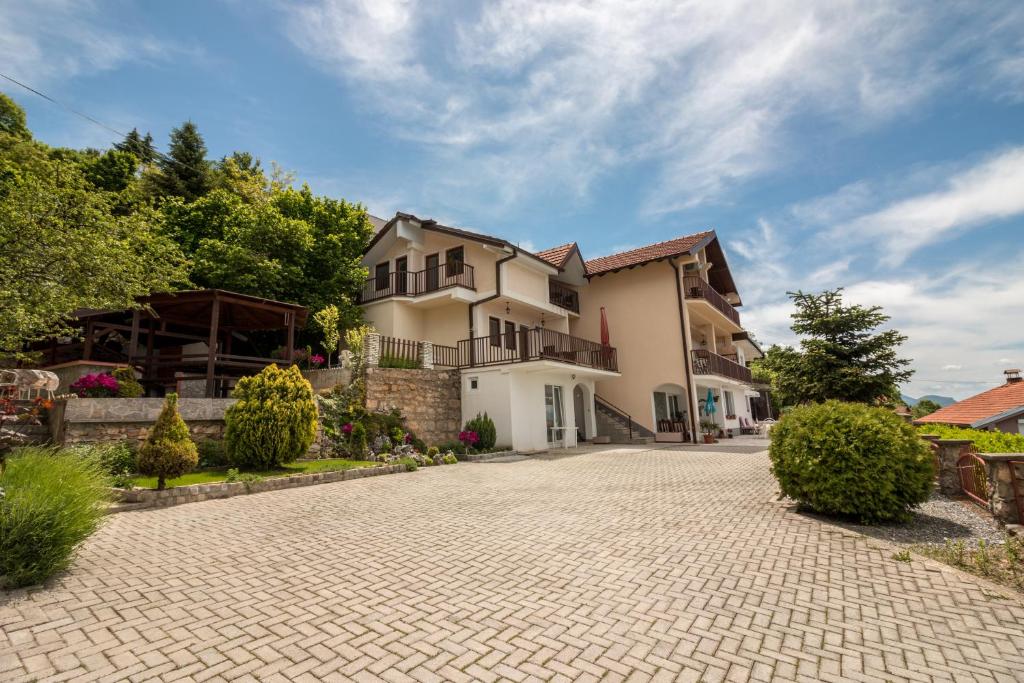 ein großes Haus mit einer Ziegelsteinfahrt in der Unterkunft Apartments Koteski in Ohrid