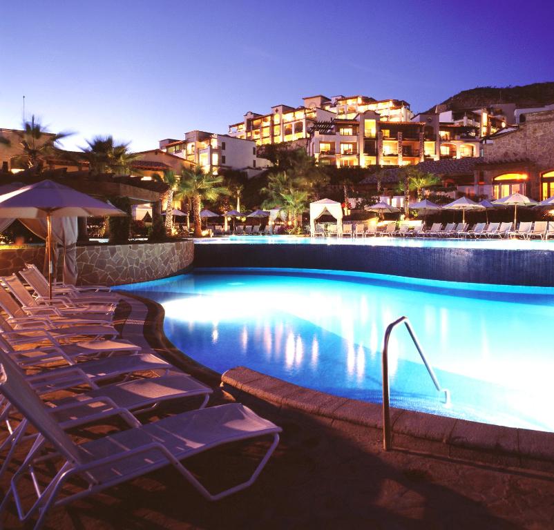a swimming pool with lounge chairs and a resort at Pueblo Bonito Sunset Beach Golf & Spa Resort - All Inclusive in Cabo San Lucas