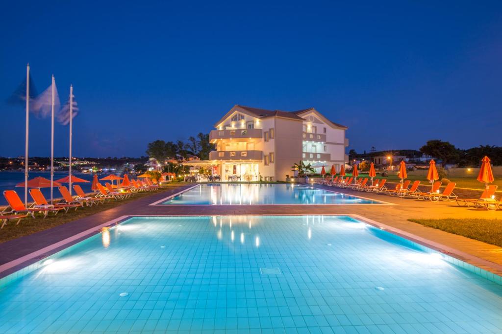 uma piscina em frente a um hotel à noite em Al Mare Hotel em Tsilivi