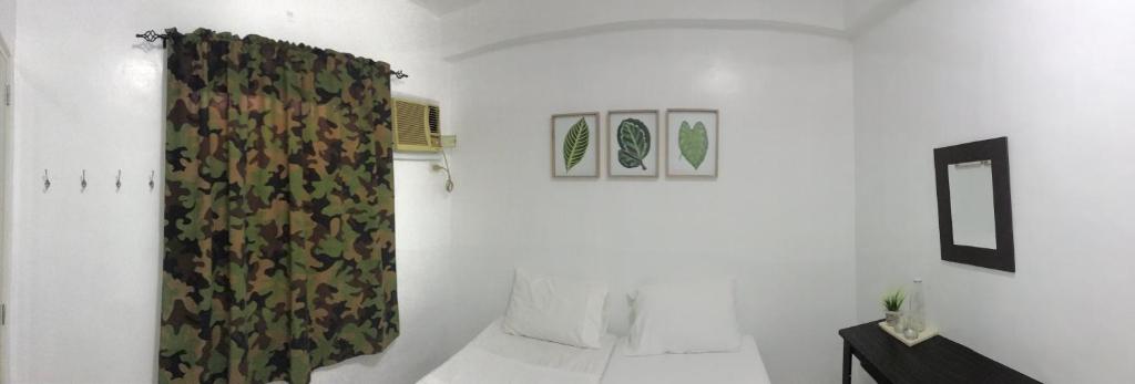 a room with a green curtain with a bed at Ignacio’s Place in Bacolod