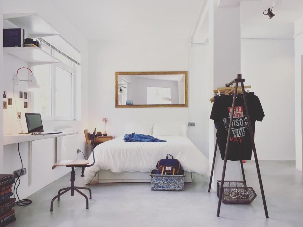 拉科魯尼亞的住宿－LOFT bed & breakfast，卧室配有1张床、1张桌子和1把椅子